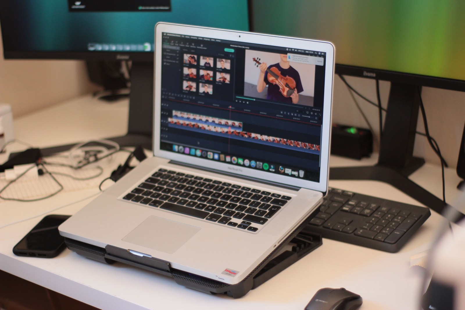 Laptop mit geöffnetem Videoschnittprogramm und Timeline auf einem Schreibtisch